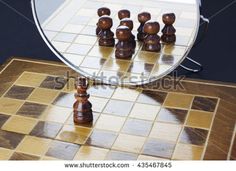 a chess board with pieces in front of a mirror