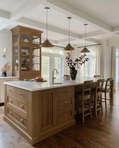 a large kitchen with an island in the middle and lots of cabinets on both sides