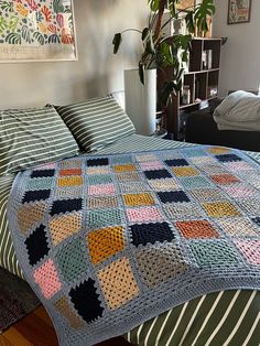 a crocheted blanket on top of a bed in a bedroom