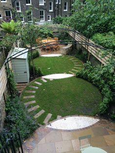 an outdoor garden with stone steps and green lawning, surrounded by brick walkways