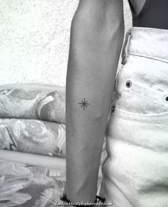 a person with a small star tattoo on their arm