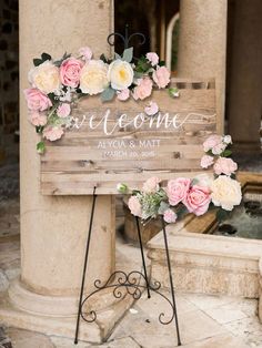 a wooden sign with flowers on it that says love and some is next to a fountain