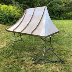 a metal structure sitting on top of a lush green field