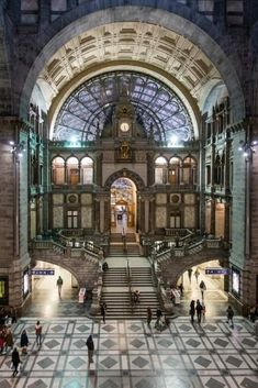 the inside of a building with many people walking around