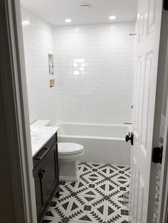 a bathroom with black and white floor tiles