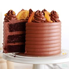 there is a chocolate cake with orange slices on the top and one slice missing from it