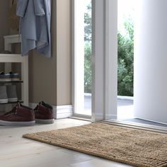 a pair of shoes sitting on top of a wooden floor next to a door with sliding glass doors