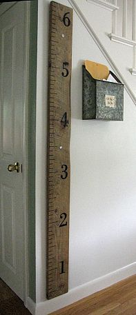 a large ruler is hanging on the wall next to a door and stair case in a house