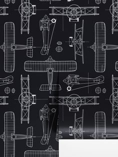 a black and white wallpaper with an airplane pattern in the middle, on top of it