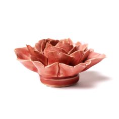 a pink flower shaped bowl sitting on top of a white table