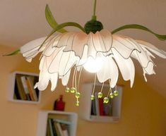 a white flower light hanging from a ceiling