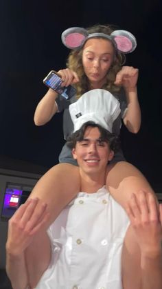 a man and woman in mouse ears on top of each other