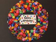 a colorful birthday wreath with the words happy birthday written on it and lots of bows