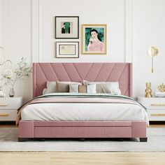 a bedroom with white walls, pink bedding and pictures on the wall above it