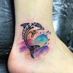 a watercolor tattoo on the foot of a woman