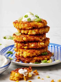 corn fritters stacked on top of each other with sour cream and green onions