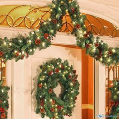 christmas wreaths with lights and pine cones hanging from the ceiling in front of a door