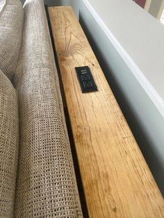 a remote control sitting on top of a wooden table next to a couch in a living room