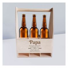 three beer bottles in a wooden crate with the label papa on it's side