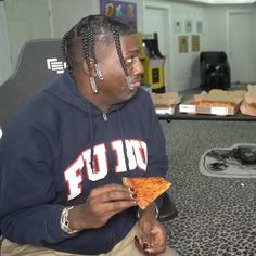 a woman sitting down eating a slice of pizza