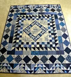 a blue and white quilt is laying on the floor