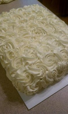 a cake with white frosting sitting on top of a table