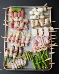 several skewered meats and vegetables on a tray with toothpicks in them