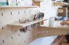 a little boy sitting at a desk with lots of pens and pencils on it