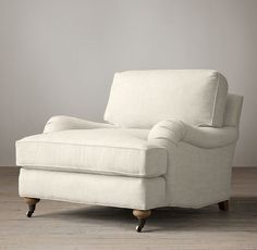 a white chair sitting on top of a hard wood floor next to a gray wall