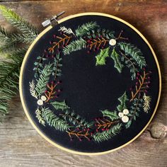 an embroidered christmas wreath on a wooden table