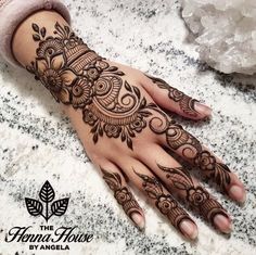 a woman's hand with henna tattoos on it