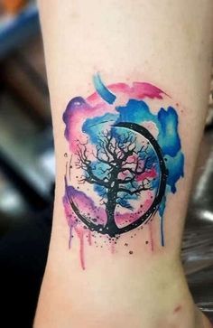 a watercolor tree tattoo on the ankle