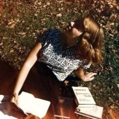 a woman laying on the ground next to some books