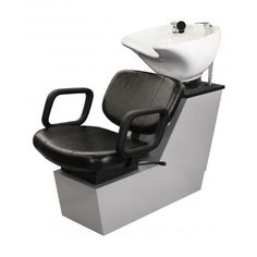 a white sink sitting next to a black chair with a faucet on it