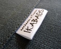 a tag that has been placed on the back of a jacket with writing on it