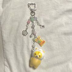 a keychain with an animal charm attached to it's side on a white shirt