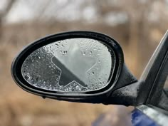 the side view mirror on a car with water droplets all over it's surface