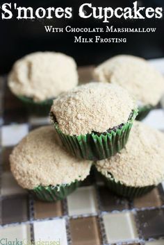 several cupcakes with white frosting and green icing sitting on a checkered tablecloth