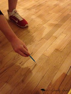 a person is holding a toothbrush in their hand on the floor next to a banana peel