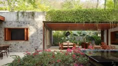 an outdoor dining area with tables and chairs, surrounded by greenery on the walls