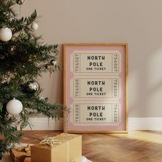 a christmas tree with presents under it next to a movie ticket poster on the wall