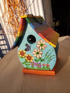 a colorful birdhouse sitting on top of a wooden table