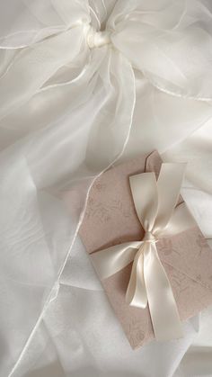 two gift boxes tied together with ribbon on white fabric and tulle skirted dress