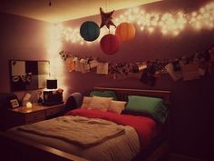 a bed room with a neatly made bed and some lights on the wall above it