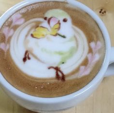 a white cup filled with liquid on top of a wooden table