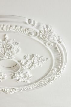 an ornate white ceiling medallion on the wall