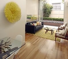 a living room filled with furniture and a large yellow ball hanging on the wall above it