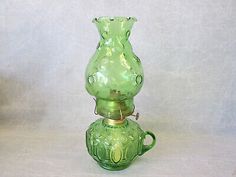 a green glass vase sitting on top of a table