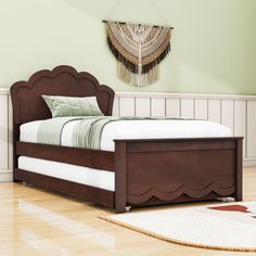 a bed sitting on top of a hard wood floor next to a white rug and green walls