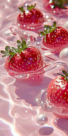 several strawberries floating in water on top of each other with bubbles and pearls around them